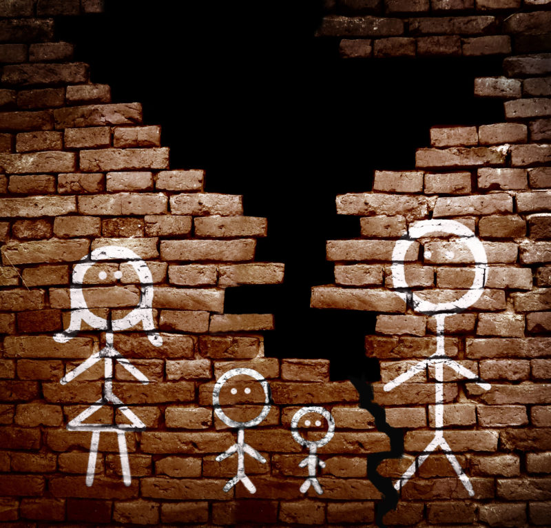 Family of stick figures on broken brick wall -- divorce or separation concept