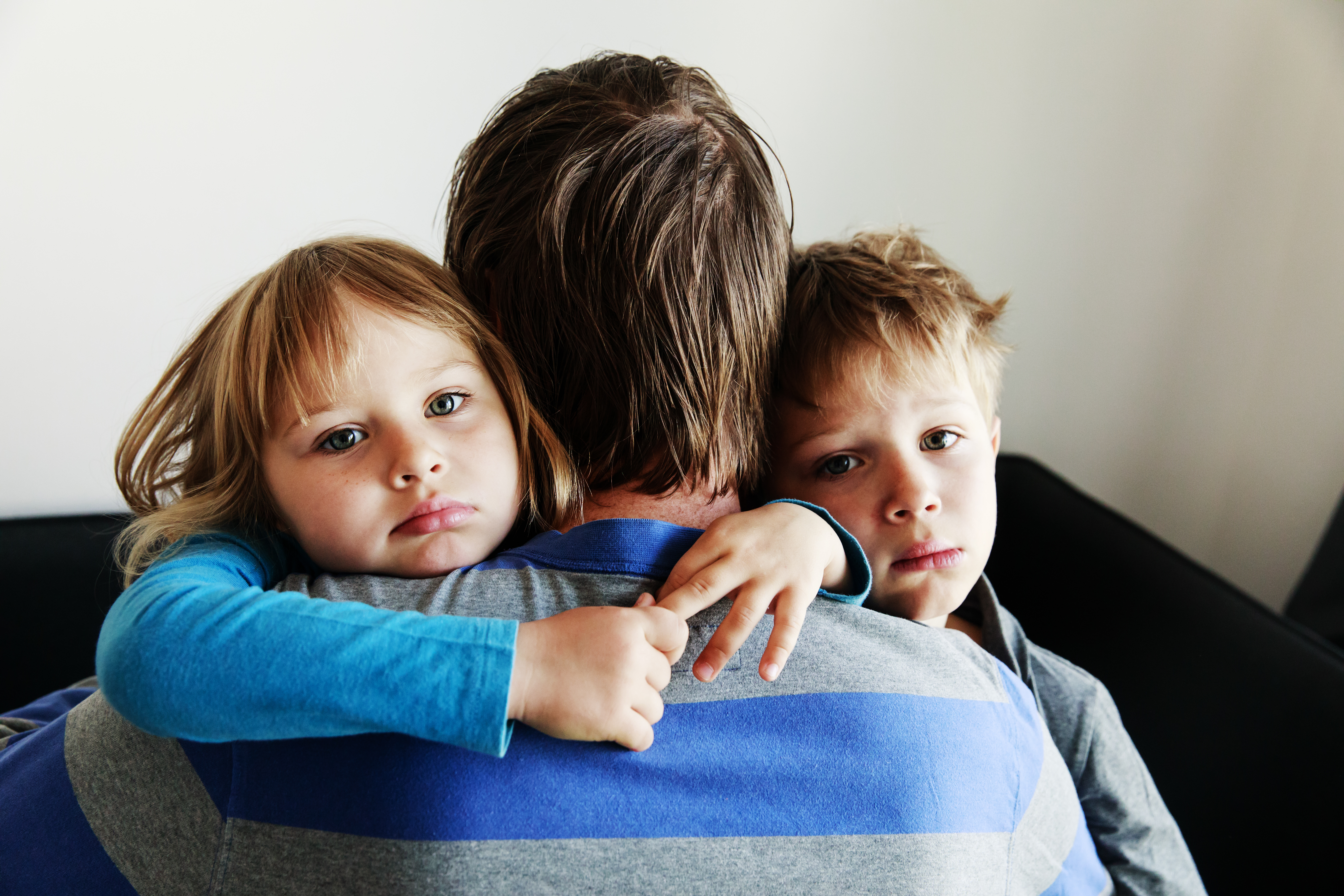 sad kids hugging father, family in sorrow, loss and pain concept